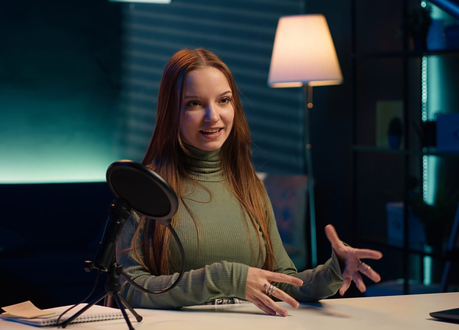 Upbeat content creator in studio filming herself discussing topics of interest for generation Z fanbase. Jolly internet star talking in microphone, recording video targeting gen Z viewers, camera A